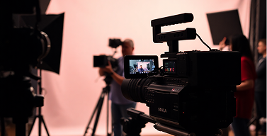Professional video camera filming in a studio with blurred background